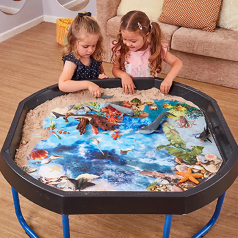 Kinderen spelen met een Tuff Tray vol zand, water en zeedieren